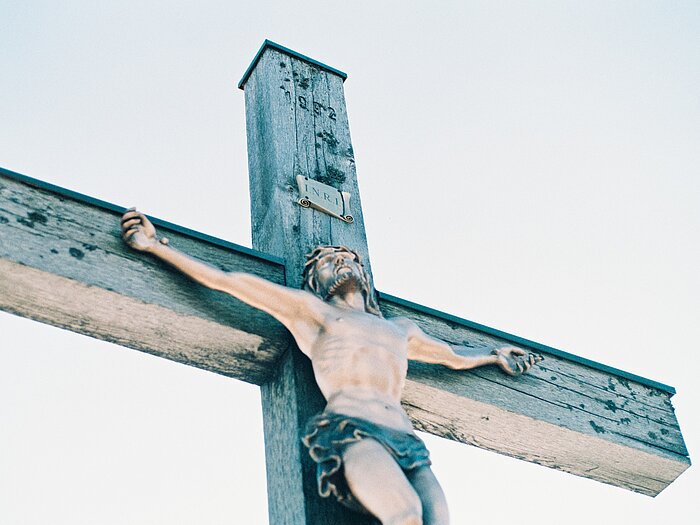 Man sieht Jesus am Kreuz hängen. Es handelt sich um ein Kruzifix.